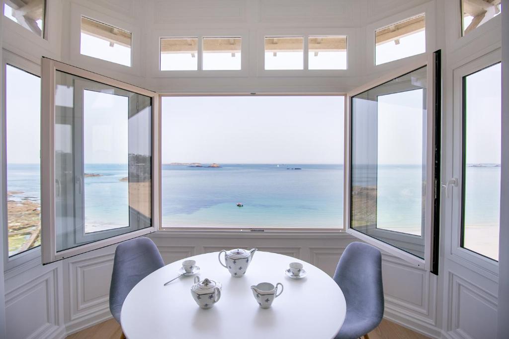 迪納爾的住宿－La Perle Marine，一间配备有桌子的海景用餐室