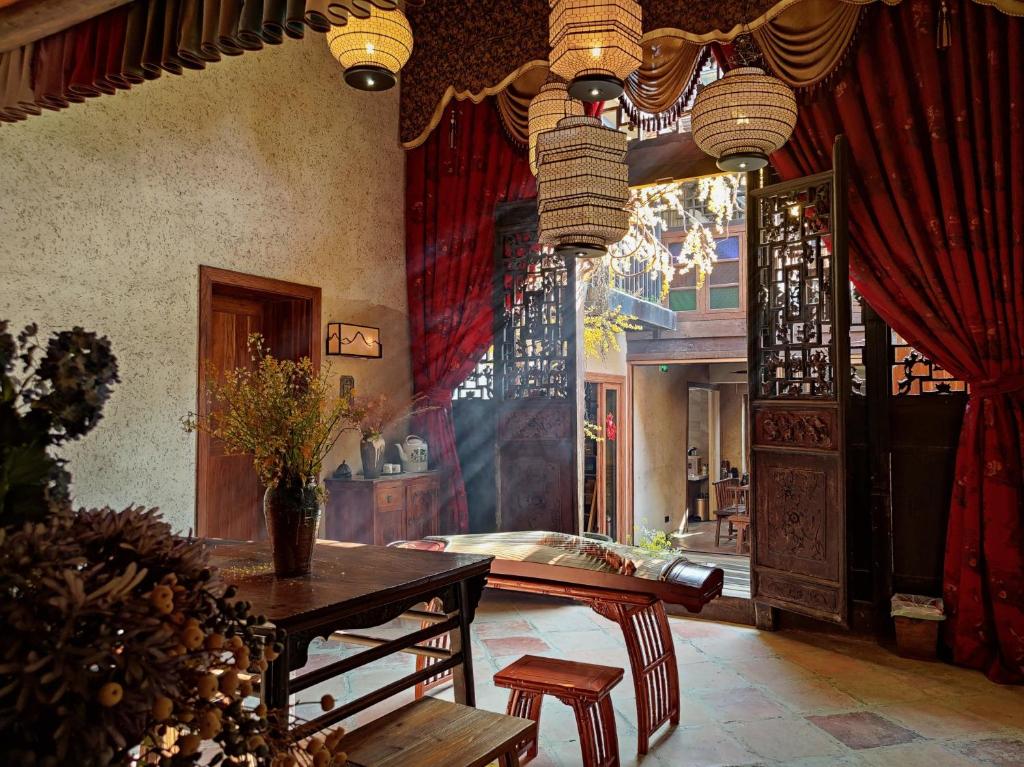 a living room with a table and red curtains at 云智慧 泊艾养生精品民宿 in Yangshuo