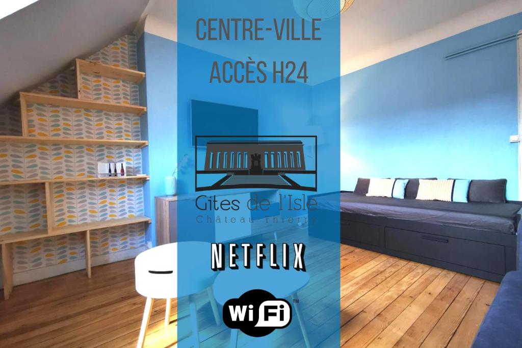 een woonkamer met een bank en een tafel bij Gites de l'isle - Séjours Pro - Wifi - Netflix - Plein centre-ville in Château-Thierry