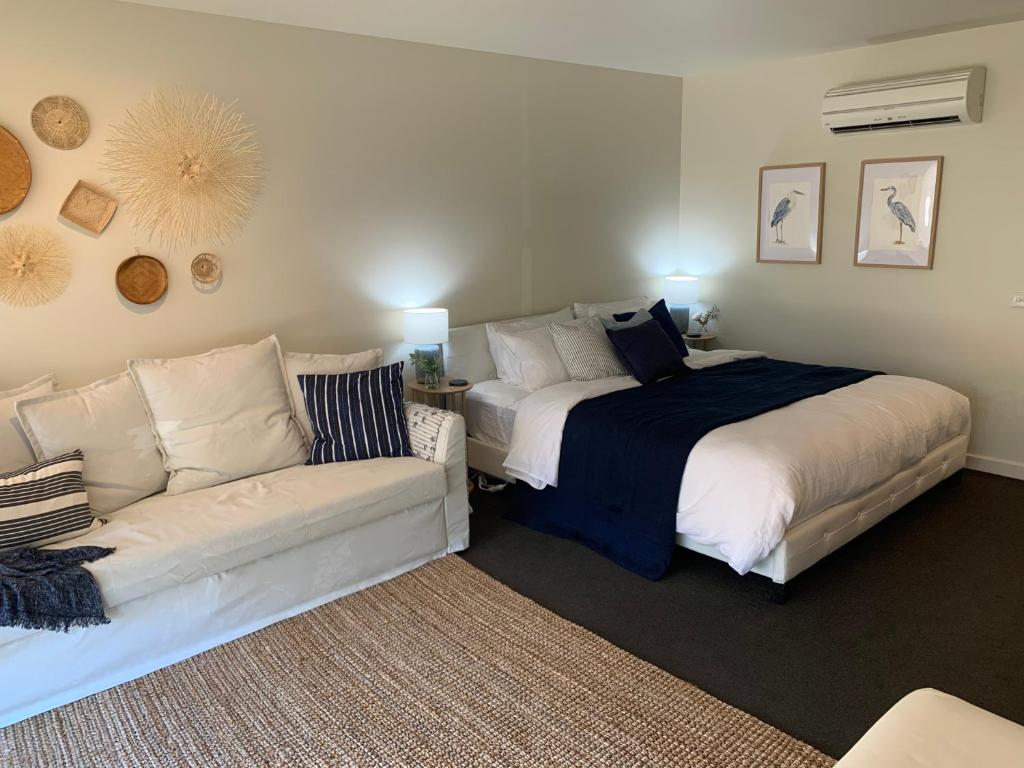 a bedroom with a bed and a couch at Lorne Studio Apartment in Lorne