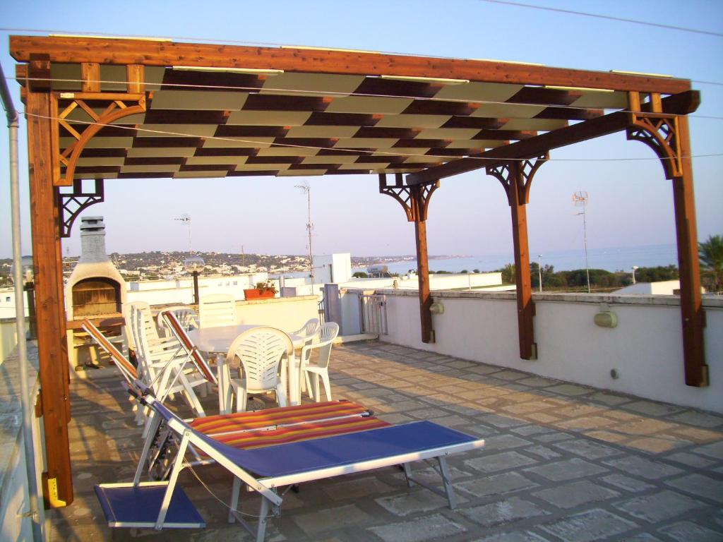 a patio with chairs and a table on a roof at Casa vacanze a Pescoluse (80 mt dal mare) in Marina di Pescoluse