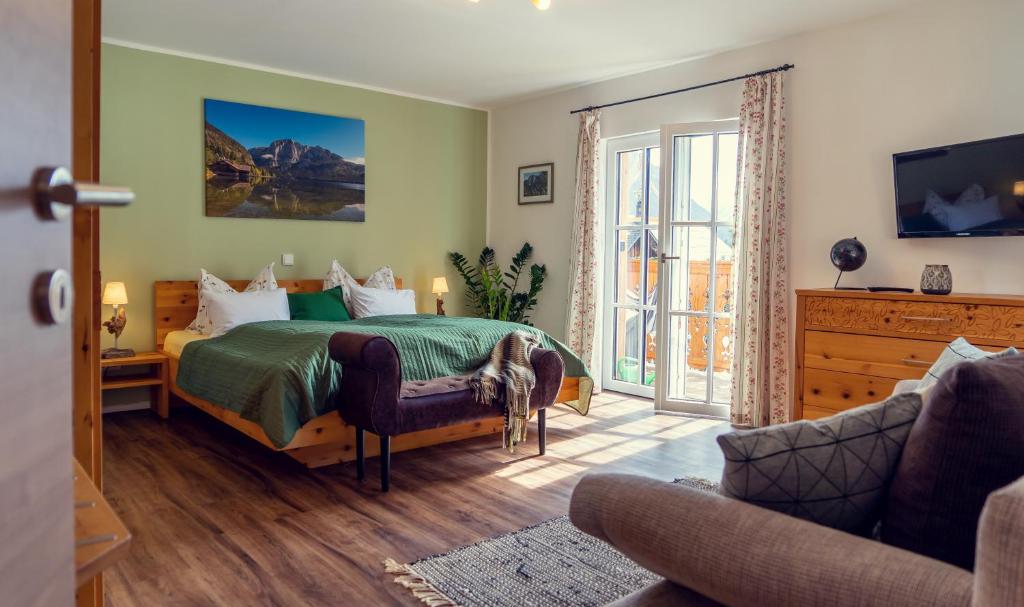 - une chambre avec un lit vert et un canapé dans l'établissement Ferienwohnung Leuner, à Altaussee