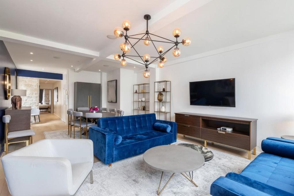 un salon avec un canapé bleu et une table dans l'établissement Stunning 2 Bedroom Apartment, à Paris