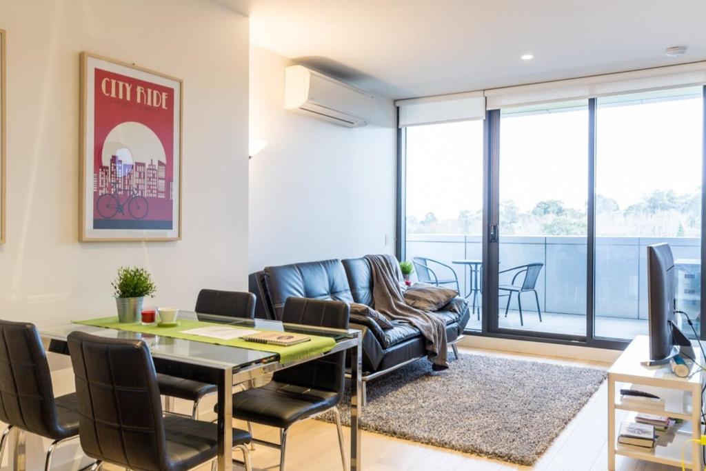 a living room with a couch and a table at Modern 1 Bedroom in Tranquil Parklands in Melbourne