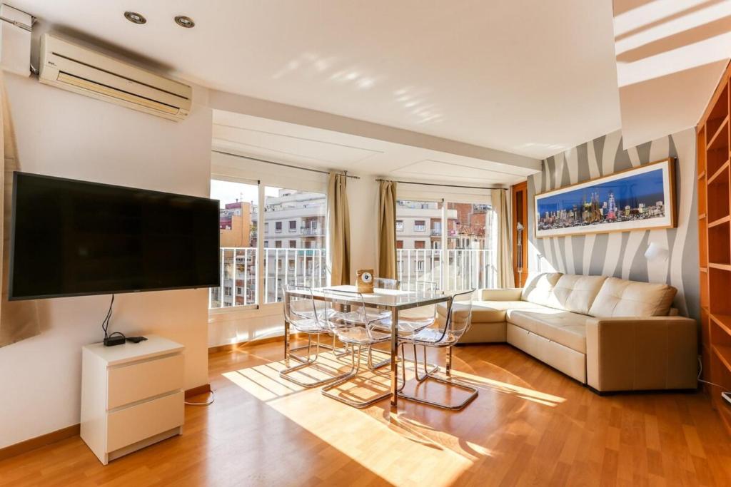 sala de estar con sofá, TV y mesa en Luminous 2 Bedroom next to Sagrada Familia, en Barcelona