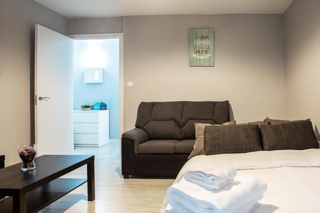 マドリードにあるLovely 3 Bedroom Apartment next to Fuencarralのリビングルーム(ベッド1台、ソファ付)