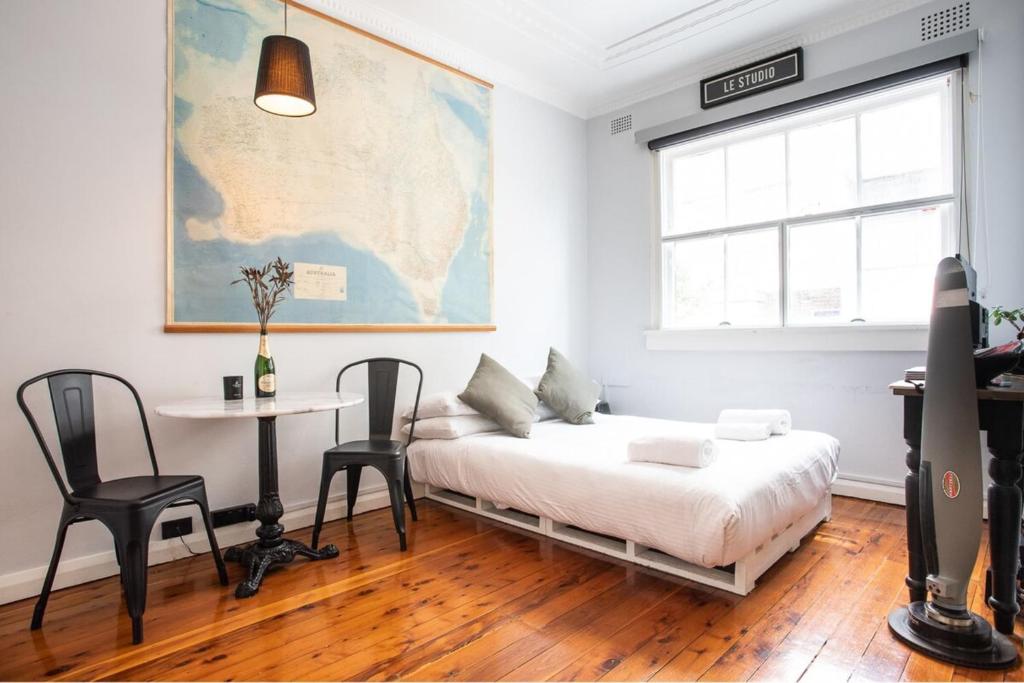 a room with a bed and a table and a map at Boutique Studio Apartment at Potts Point in Sydney