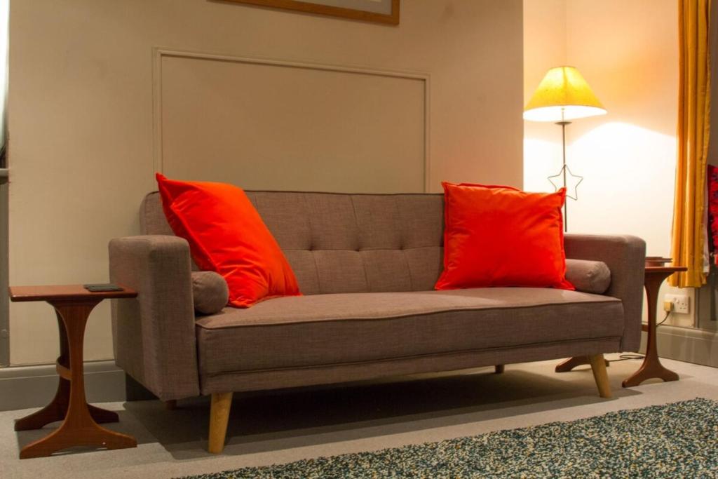 - un canapé avec deux oreillers rouges dans le salon dans l'établissement The North Laine Boutique Brighton, à Brighton et Hove