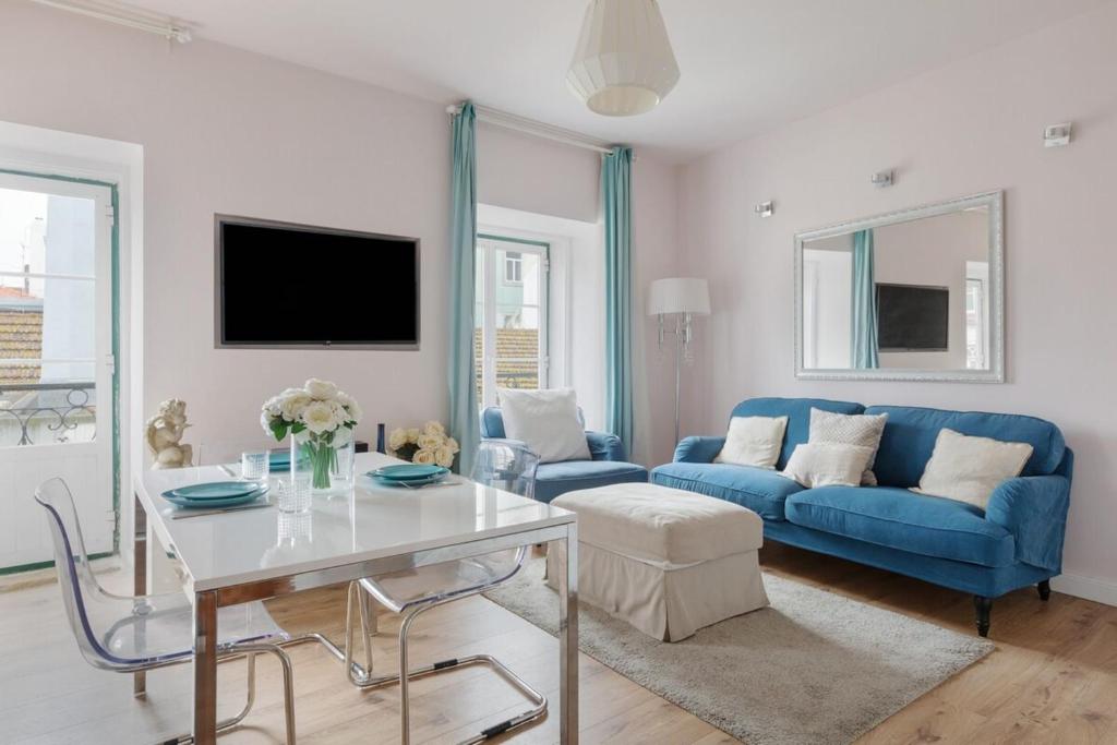 リスボンにあるCharming bright Apartment in Lisbonのリビングルーム(青いソファ、テーブル付)