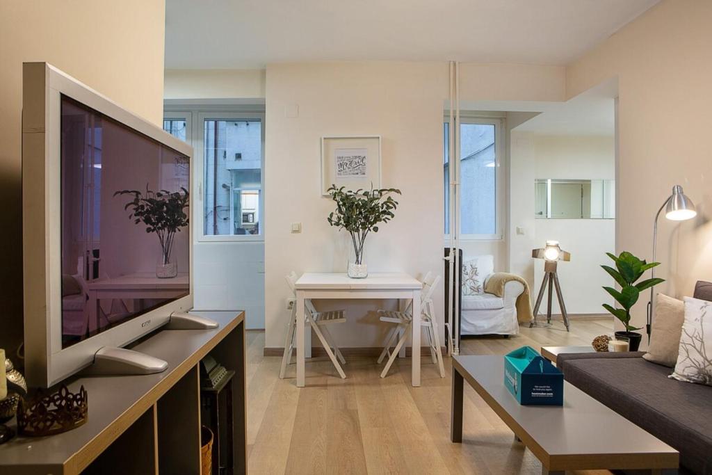 sala de estar con TV y sofá en Modern 2 Bed Apartment near Las Ventas, en Madrid