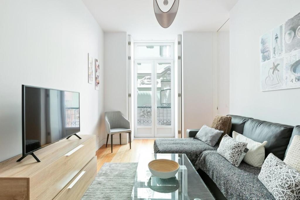 Il comprend un salon doté d'un canapé et d'une télévision à écran plat. dans l'établissement Spacious 1 Bedroom Apartment near Baixa, à Lisbonne