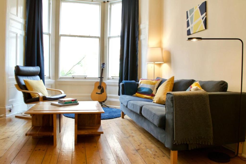 エディンバラにあるBeautiful Traditional 3 Bedroom Apartment in Edinburghのリビングルーム(ソファ、テーブル付)