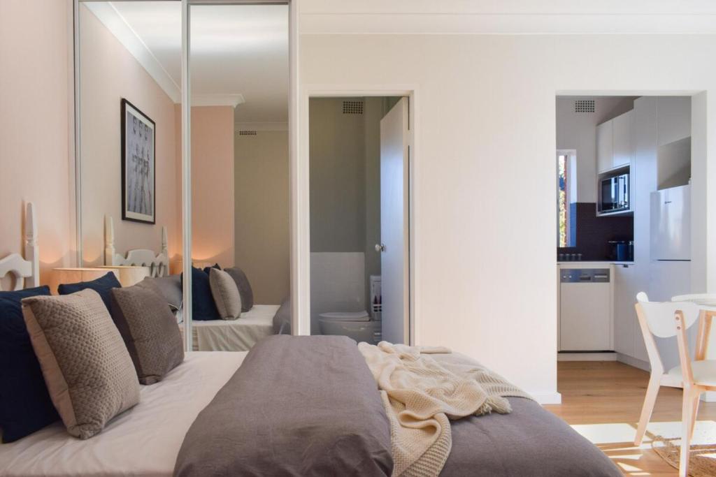 a bedroom with a large bed with a large mirror at Sun-Drenched 1 Bed Studio Apartment In Newtown in Sydney