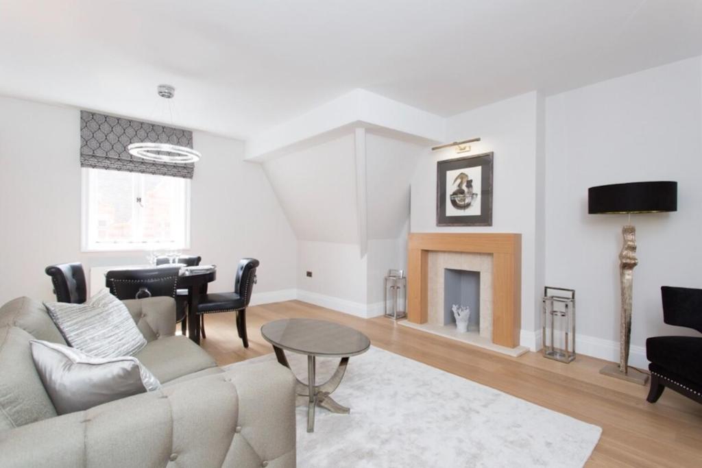 een woonkamer met een bank en een tafel bij Luxury Mayfair 2 Bedroom Apartment in Londen