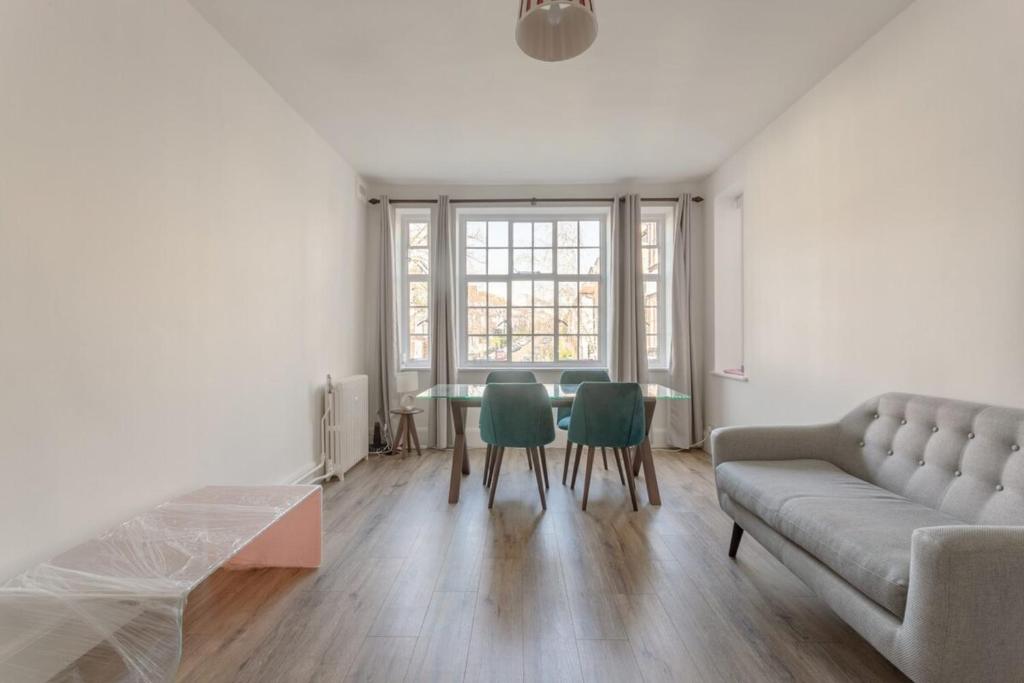 a living room with a couch and a table at Bright and Lovely 1 Bedroom Flat Belsize in London