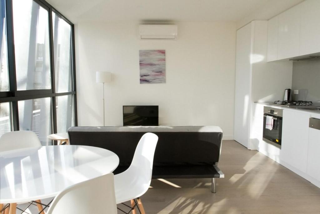 a kitchen and dining room with a table and chairs at Brand New 1 Bedroom Apartment in South Melbourne in Melbourne