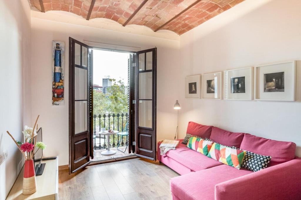 バルセロナにあるDesign 1 Bedroom Apartment near Plaza Españaのリビングルーム(ピンクのソファ、バルコニー付)