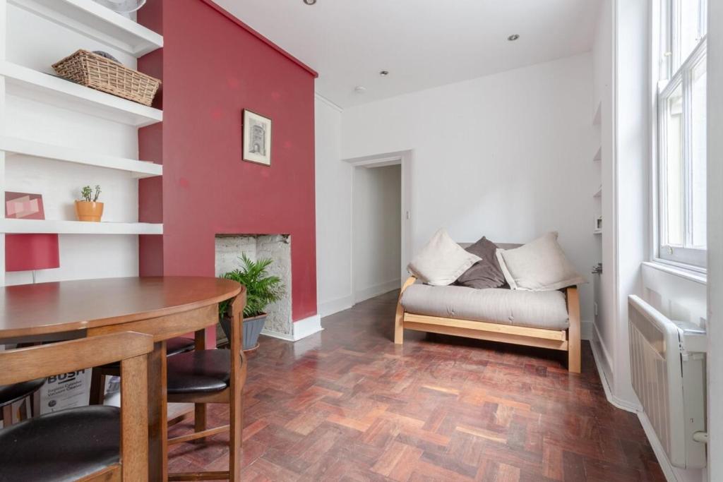 a living room with a couch and a red wall at Modern 2 Bedroom flat in Central London in London