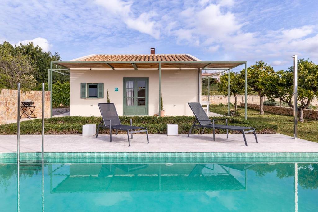een huis met een zwembad en twee stoelen bij Sa Verdal in Selva