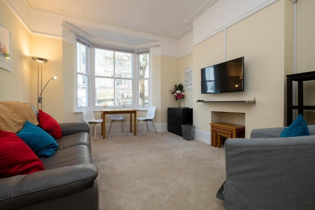 uma sala de estar com um sofá e uma mesa em Bright City Centre Flat with Sea 2 Minutes Away em Brighton & Hove