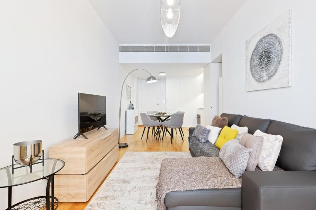 a living room with a gray couch and a table at Spacious 1 Bedroom Apartment near Baixa in Lisbon