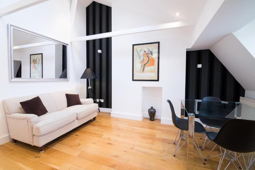 een woonkamer met een witte bank en een glazen tafel bij Contemporary 1 Bed Flat in Fulham Near The Thames in Londen