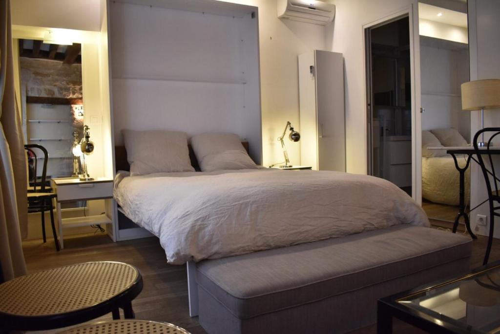a bedroom with a bed and a table and a chair at Charming studio near République and Le Marais in Paris