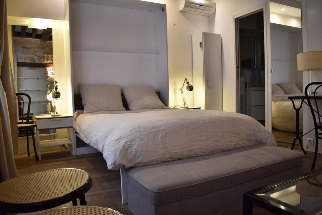 une chambre avec un lit, une table et une chaise dans l'établissement Charming studio near République and Le Marais, à Paris