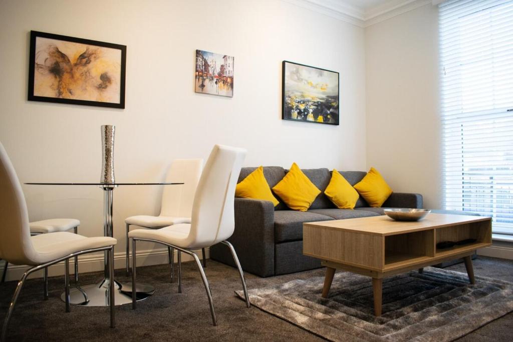 エディンバラにあるBeautifully Renovated Apartment -Central Edinburghのリビングルーム(ソファ、テーブル、椅子付)
