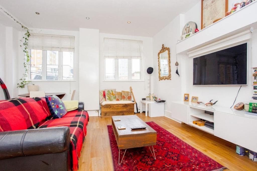 a living room with a couch and a tv at Trendy East London Apartment near Shoreditch in London