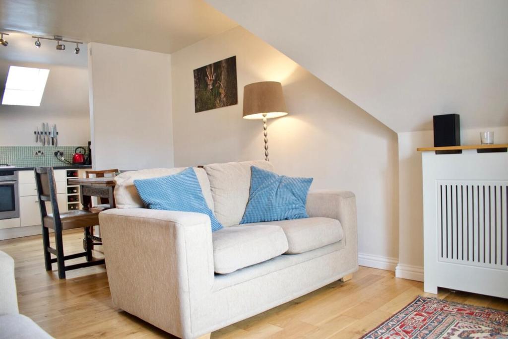 a living room with a white couch with blue pillows at Modern and Charming 2 Bedroom Old Town Apartment in Edinburgh