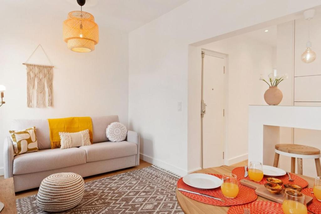 a living room with a couch and a table at Modern Portuguese 1 Bedroom Apartment in Belém in Lisbon