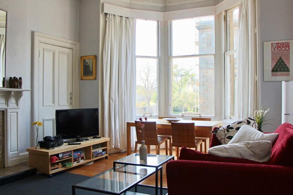 a living room with a couch and a tv at Classic Edinburgh Flat in the heart of Morningside in Edinburgh