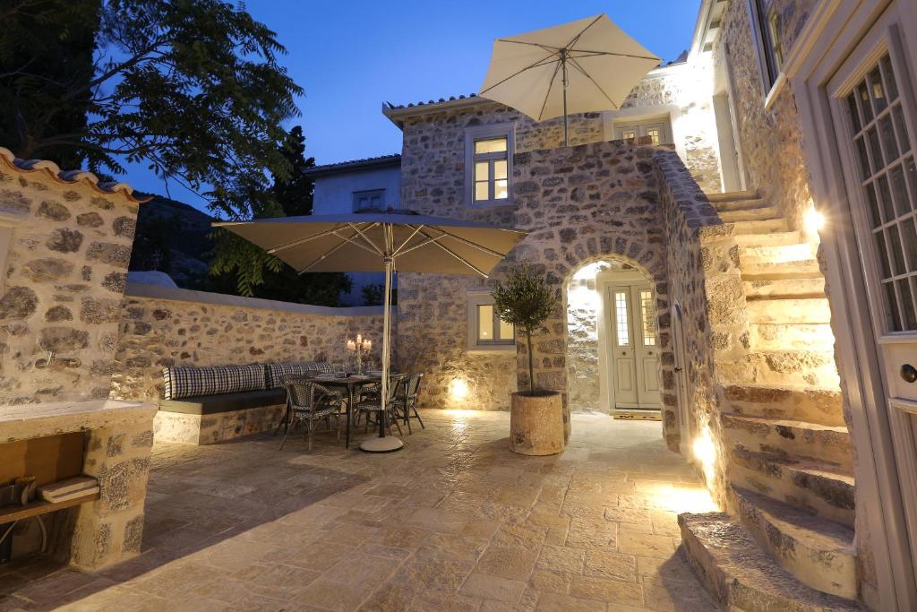 a patio with an umbrella and a table at La Maison de Marie Geraldine in Hydra