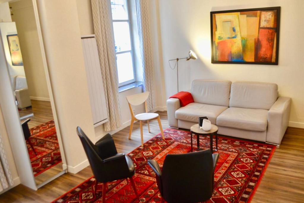 パリにある1 Bedroom Apartment in the Heart of the Marais areaのリビングルーム(ソファ、椅子付)