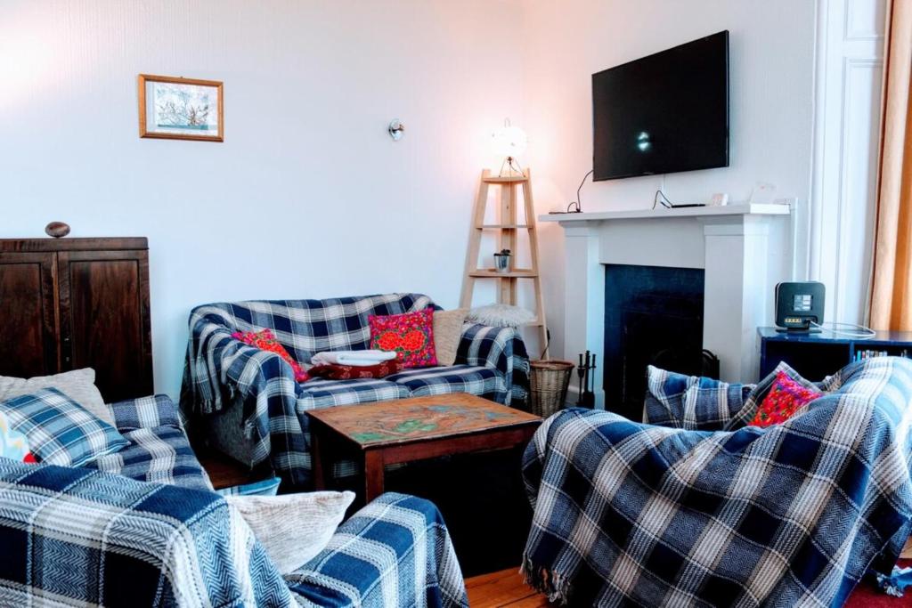 a living room with two couches and a fireplace at Traditional Apartment oer the Meadows in Edinburgh