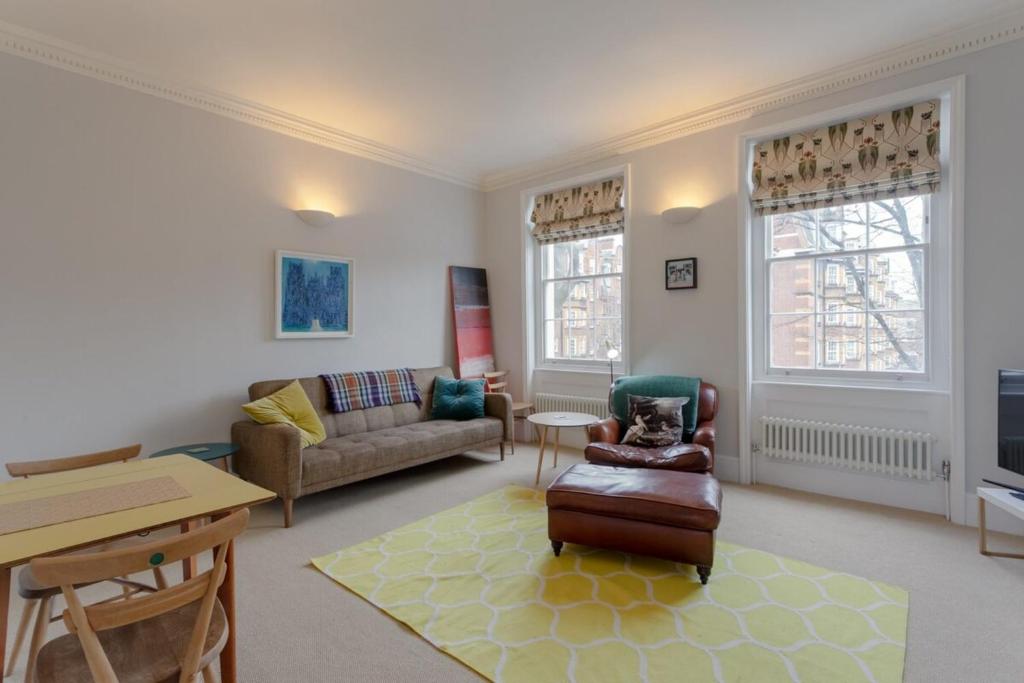 Vibrant 1 Bedroom Flat In Islington With Garden في لندن: غرفة معيشة مع أريكة وطاولة