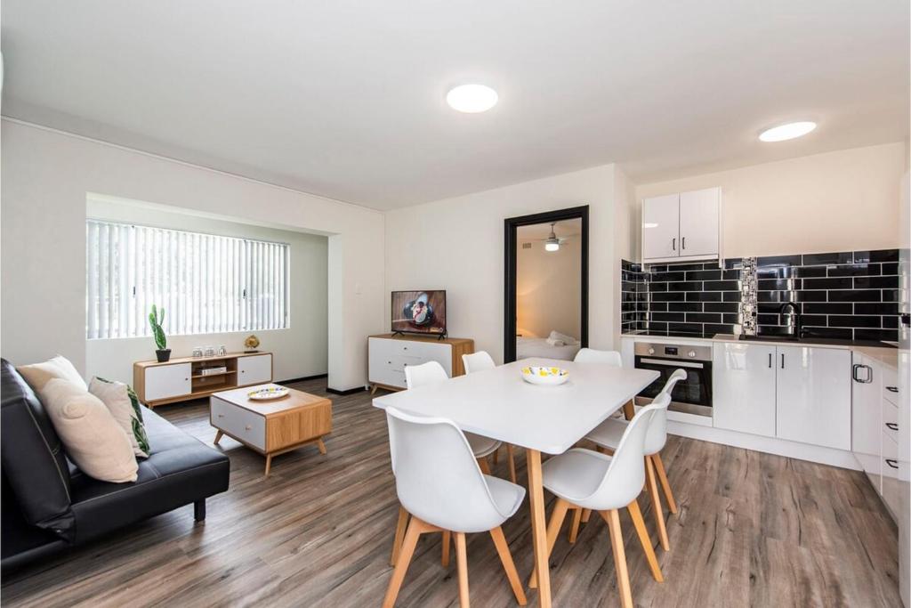 a kitchen and a living room with a table and chairs at Stylish Apartment in Leafy South Perth in Perth