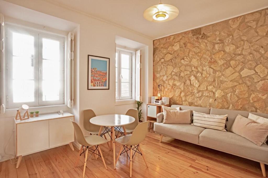 een woonkamer met een bank en een tafel bij Renovated cosy 1Bedroom Apartment in Santos in Lissabon