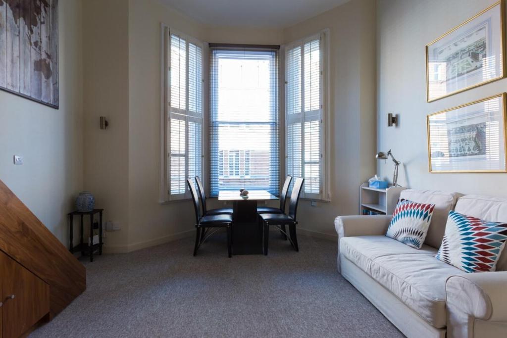 Modern 1 bed Flat in Knightsbridge في لندن: غرفة معيشة مع أريكة وطاولة