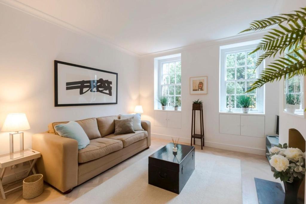 ロンドンにあるBright and Leafy 1 Bedroom Flat in the Heart of Chelseaのリビングルーム(ソファ、テーブル付)