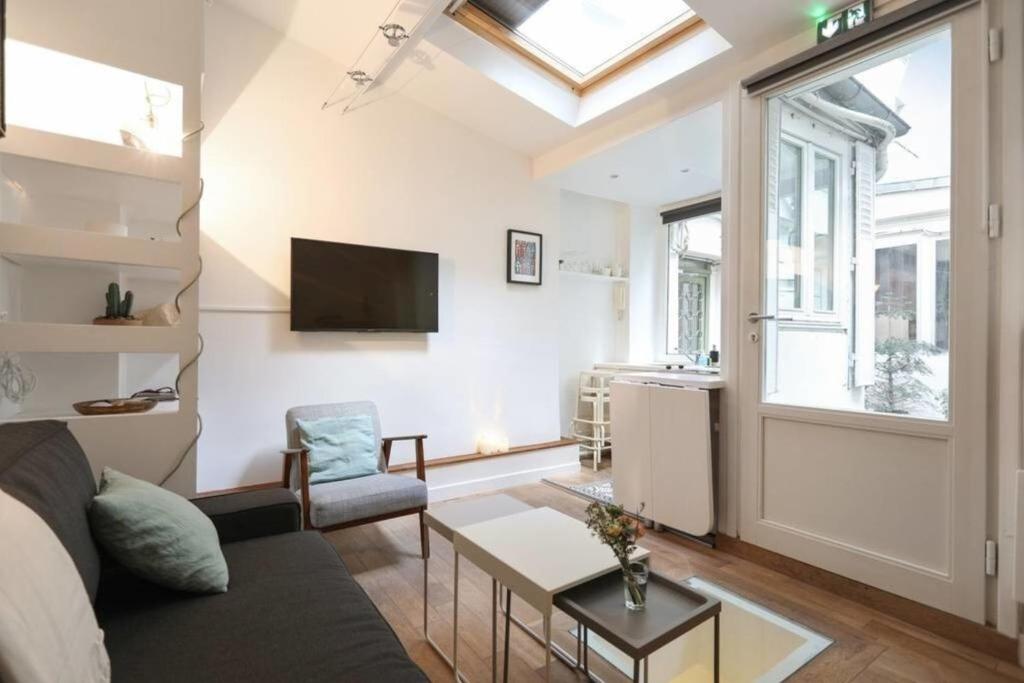 a living room with a couch and a tv at Modern 1 Bedroom Apartment near Eiffel Tower in Paris