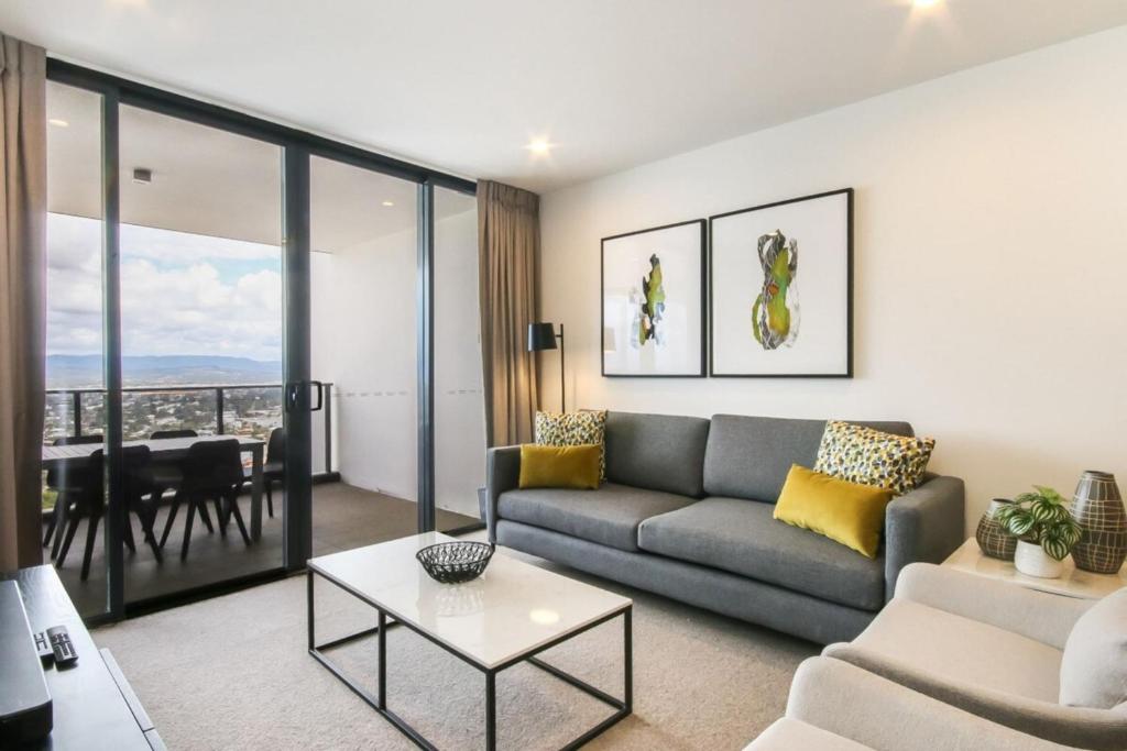 een woonkamer met een bank en een tafel bij Luxurious 2 Bedroom Brand New Apartment With Amazing Hinterland Views in Gold Coast