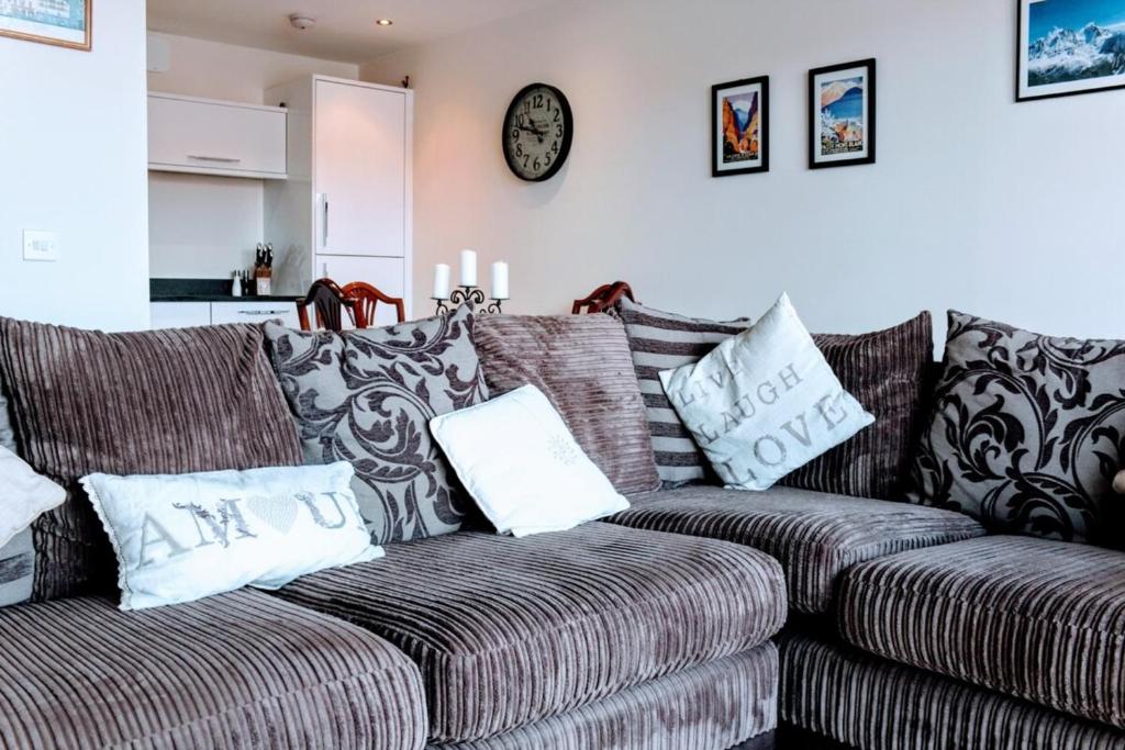 a living room with a couch and a clock on the wall at Modern Apartment in Edinburgh in Edinburgh