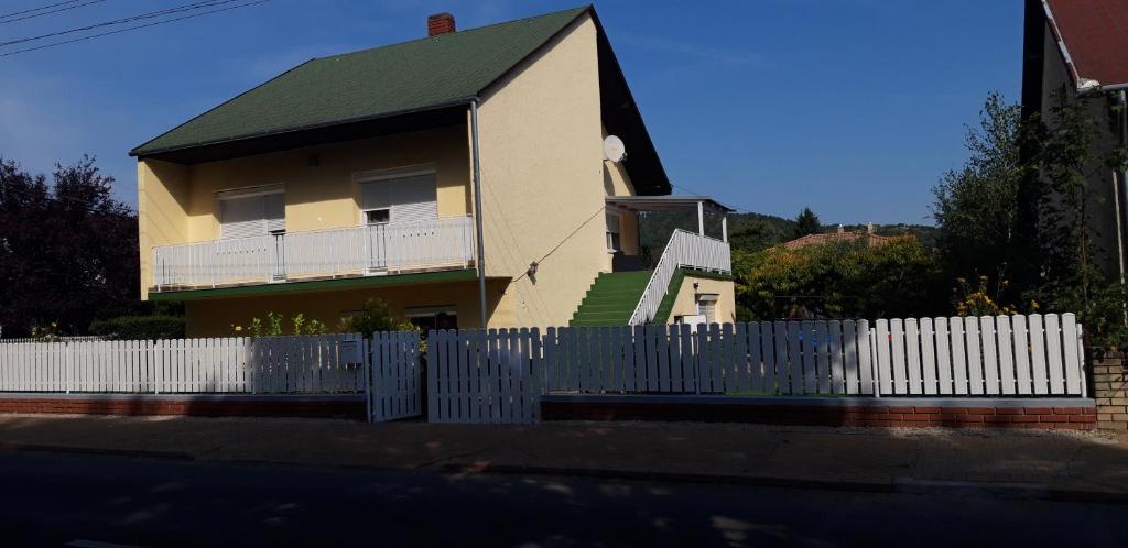 a house with a white picket fence in front of it at Ildi Apartman in Gyenesdiás