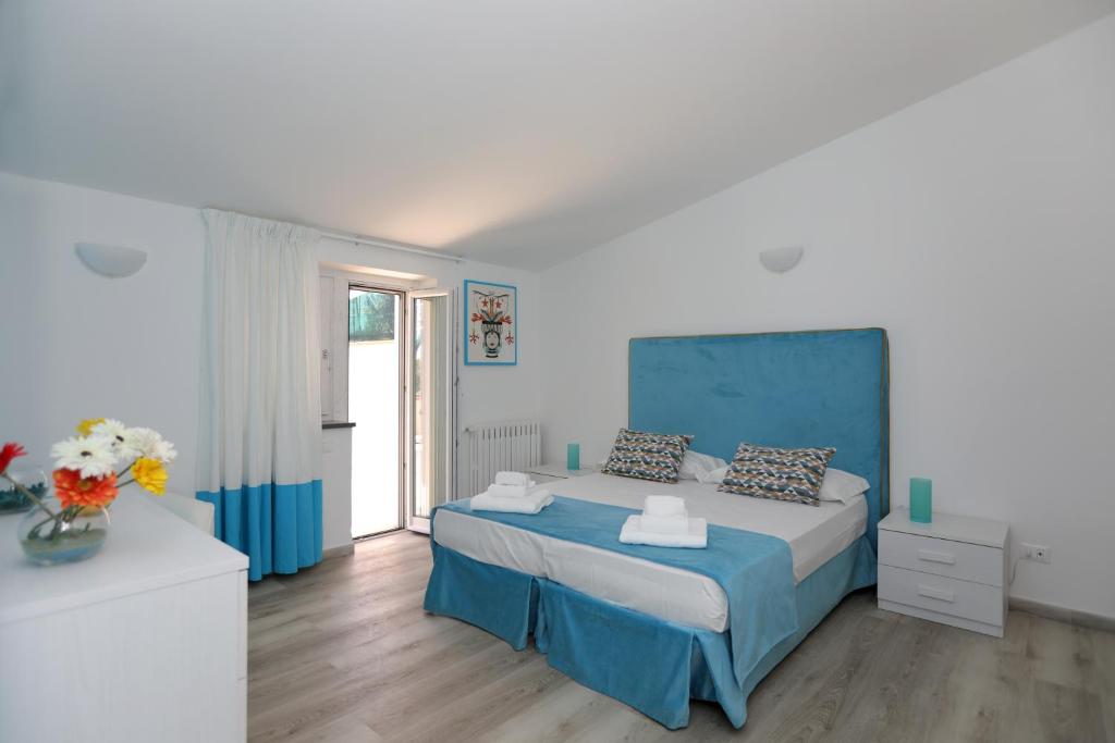 Schlafzimmer mit einem Bett mit blauem Kopfteil in der Unterkunft Relais Villa Chiara free parking in Sorrent