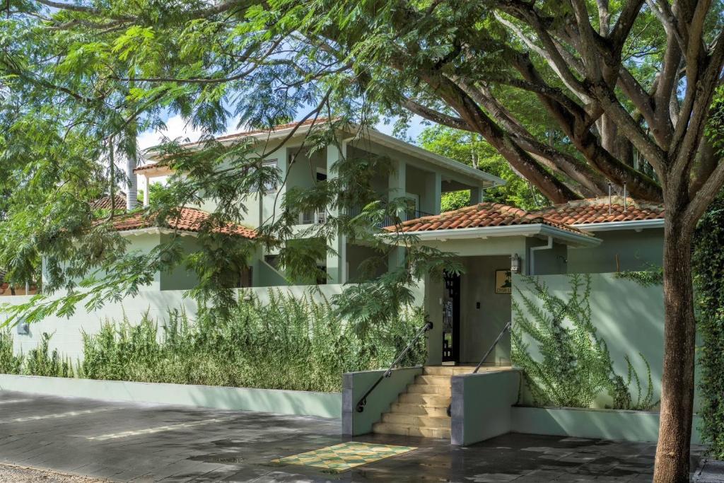 una casa con un árbol delante de ella en Hotel Casa Leona en Tamarindo
