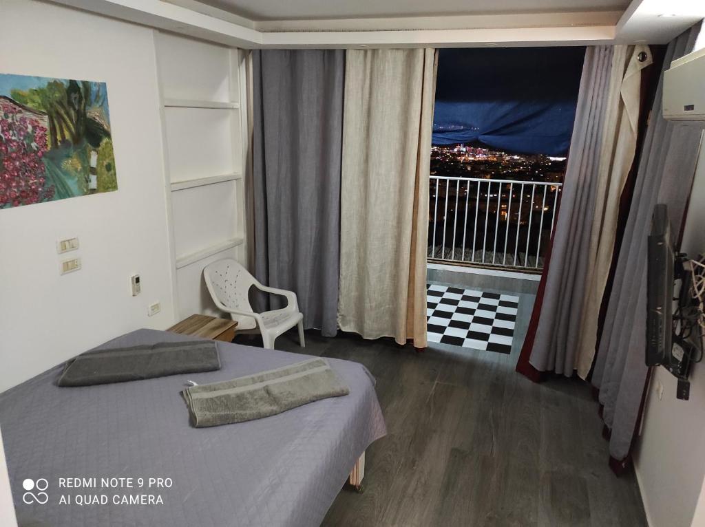 a bedroom with a bed and a window with a balcony at Eilat in Eilat