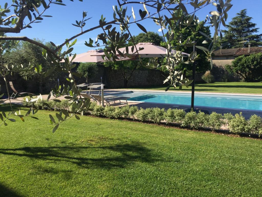 uma piscina num quintal com um campo de relva em DIMORA DESENZANI - Lago di Garda em Esenta