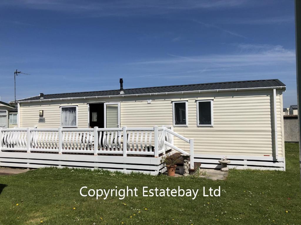 a white holiday house with a white fence at Cherry Tree 14, Lyons Robin Hood Park in Rhyl